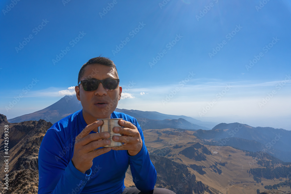 Young Man Drinking Hot coffee In The Mountain