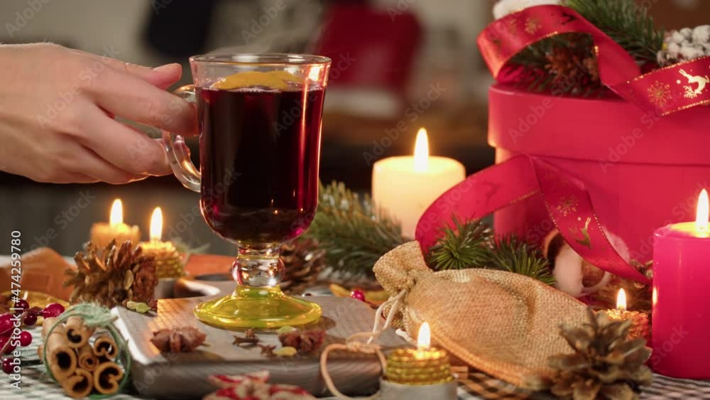 Hot wine in glass mugs, gluhwein and cinnamon close-up. Mulled red wine with star anise, decorative pinecones, blowing candles. Traditional winter drinks. Christmas holidays and new year time concept. Hot wine in glass mugs, gluhwein and cinnamon close-up. Mulled red wine with star anise, decorative pinecones, blowing candles. Traditional winter drinks. Christmas holidays and new year time concept.