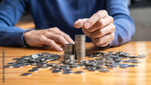 Young man and pile coins to planning growing saving strategy with pile coins for future plan fund of travel, education, home and retirement