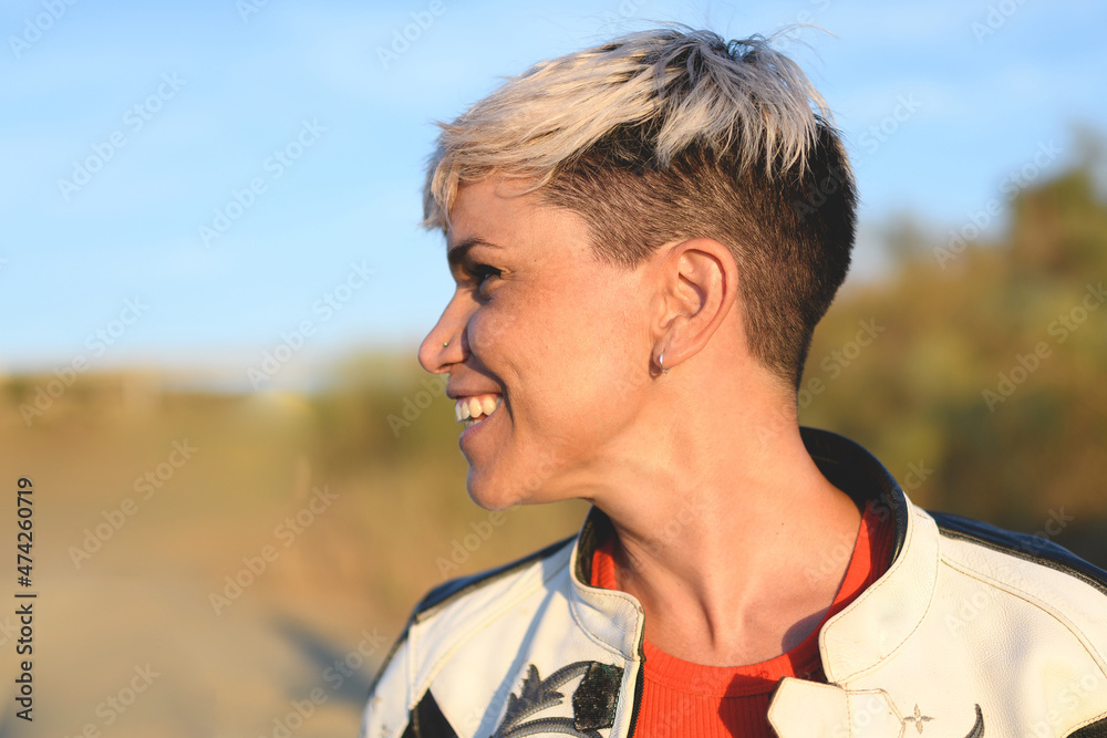 profile portrait of a young smiling pretty woman with modern haircut, shaved at the nape, short blonde profile portrait of a young smiling pretty woman with modern haircut, shaved at the nape, short blonde