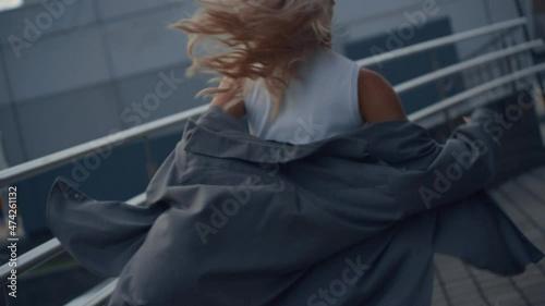 Female person running away from camera in city centre downtown building.  photo