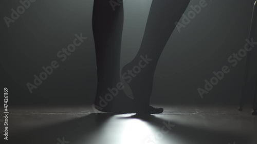 Closeup of Woman dancer stretching her feet with backlight