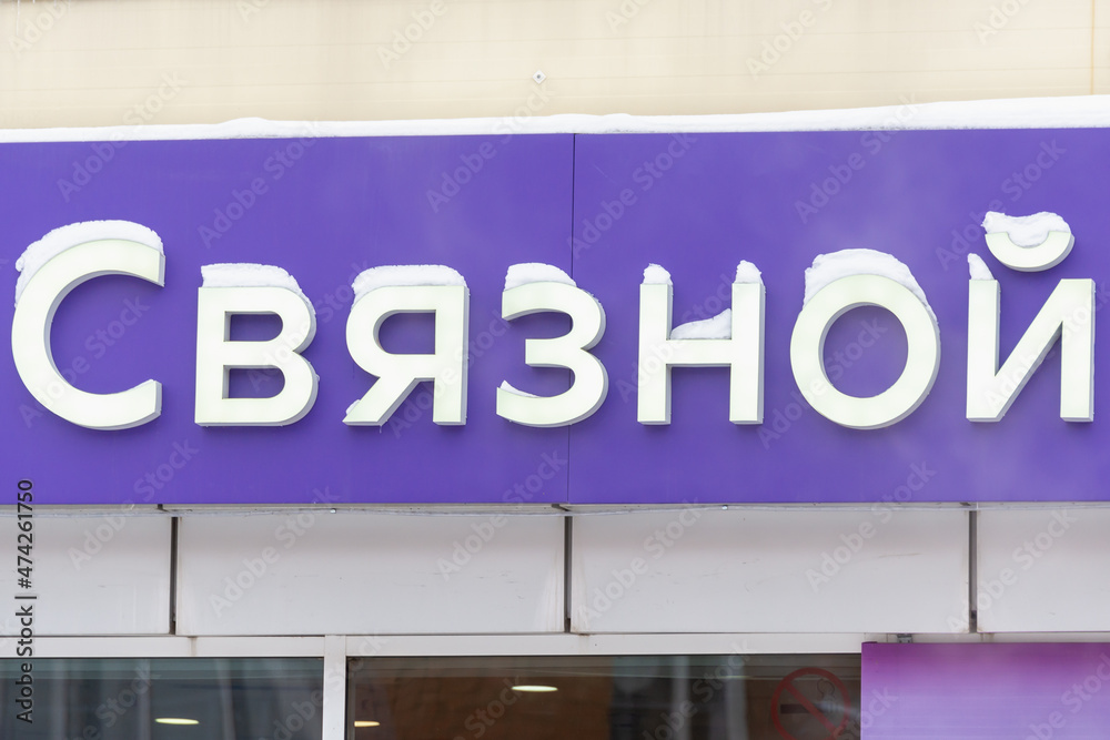 A sign on the store building with an inscription in Russian: Svyaznoy