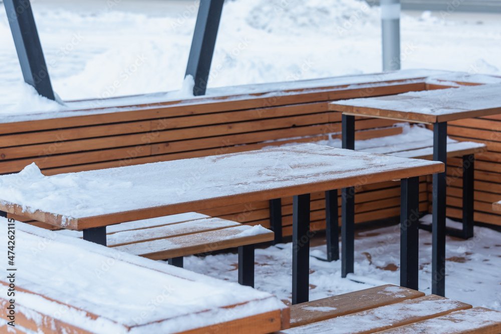 Cafe, snow-covered tables and benches.