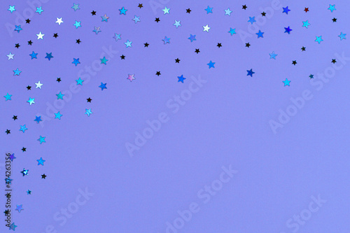 Shiny glitter stars on purple, very peri color background. Abstract Christmas, New Year, festive background photo