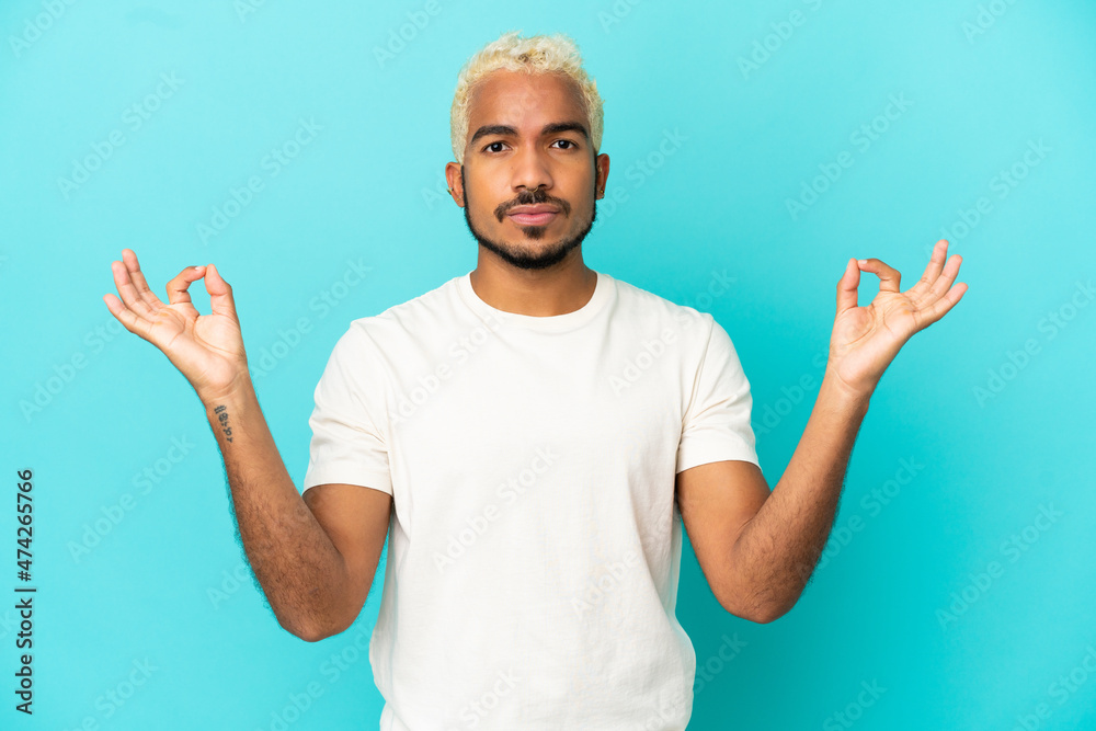 Naklejka premium Young Colombian handsome man isolated on blue background in zen pose