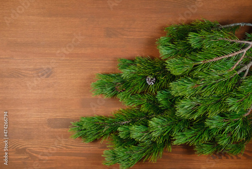 Christmas tree branch on wooden background. Xmas and Happy New Year theme. Flat lay, top view. Copy space
