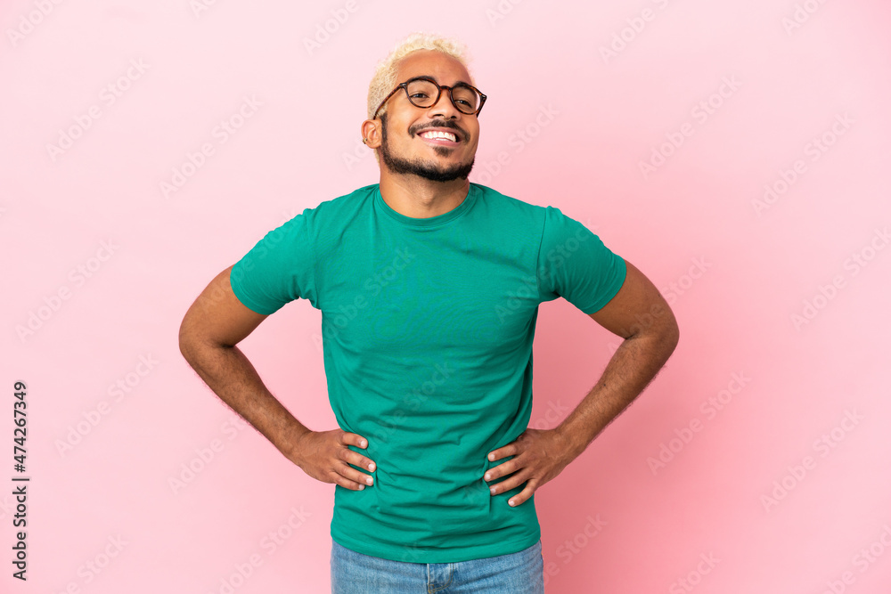 Young Colombian handsome man isolated on pink background posing with arms at hip and smiling Young Colombian handsome man isolated on pink background posing with arms at hip and smiling