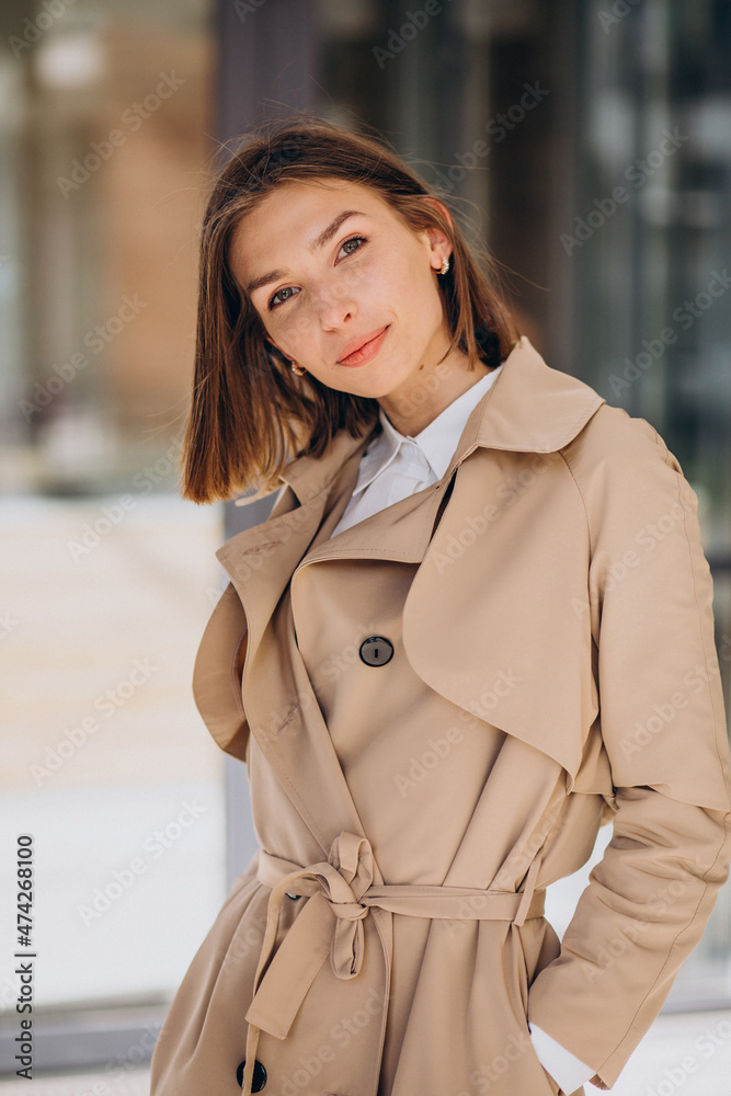 Fototapeta premium Young beautiful woman wearing coat walking in the city