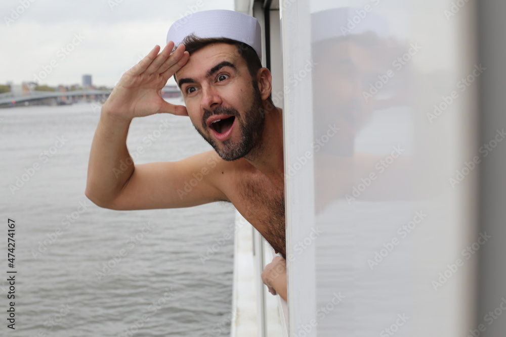 Shirtless sailor looking at the horizon in deck Shirtless sailor looking at the horizon in deck