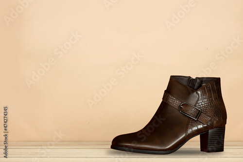 stylish leather ankle boot on wood table 