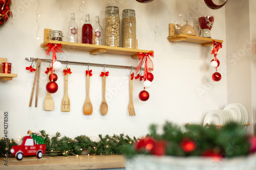 Kitchen wooden countertop with hob and kitchenware decorated for winter holidays new year christmas
