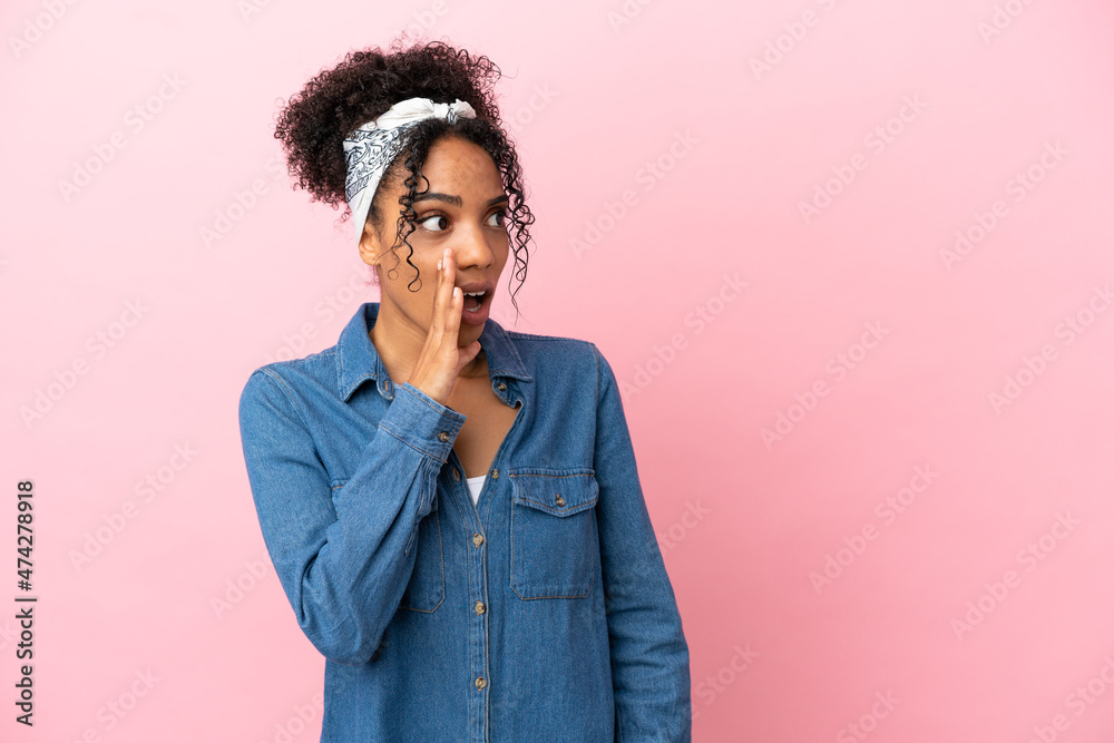 Young latin woman isolated on pink background whispering something with surprise gesture while looking to the side Young latin woman isolated on pink background whispering something with surprise gesture while looking to the side