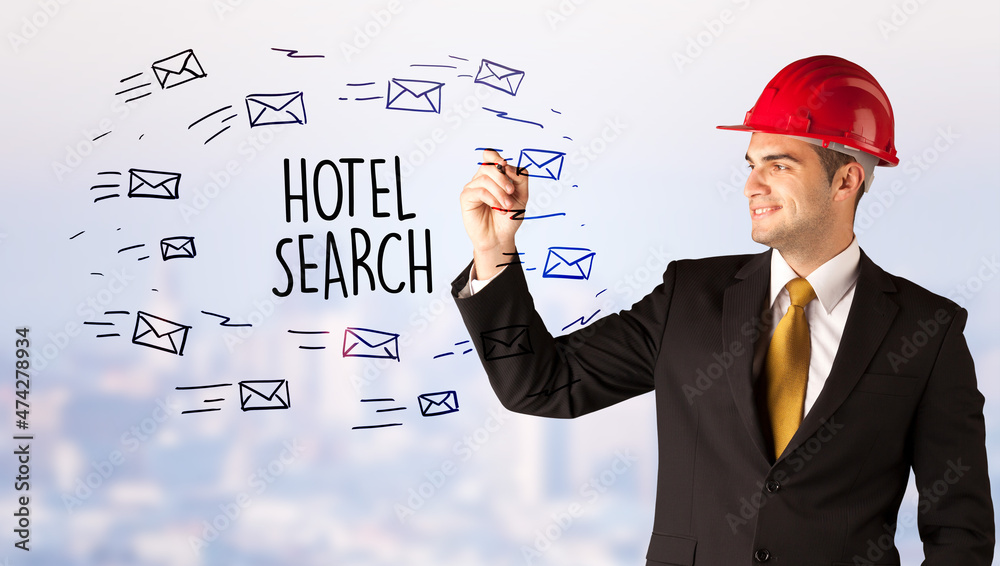 Young businessman with helmet drawing sale sign Young businessman with helmet drawing sale sign
