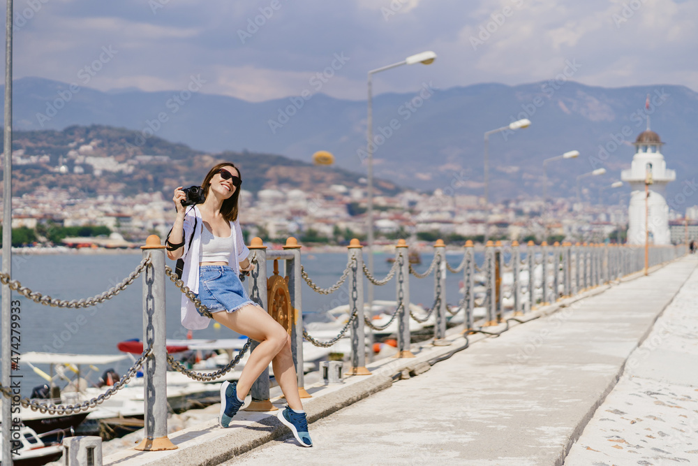 Turkey travel tourist woman on vacation in the Alanya sitting on embankment. Turkey summer destination.