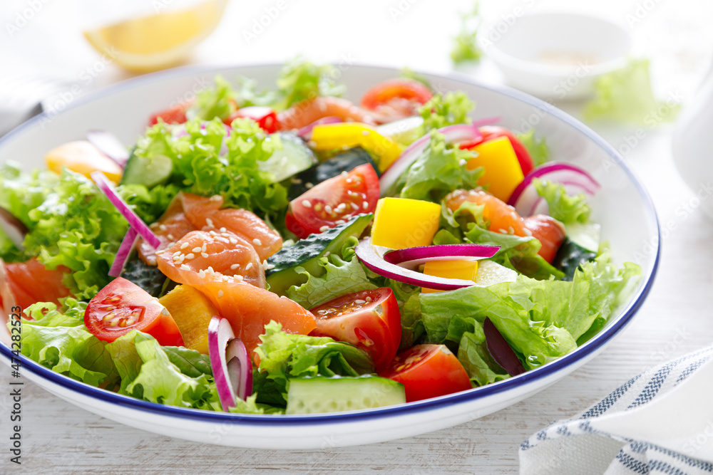Salted salmon salad with fresh green lettuce, cucumbers, tomato, bell pepper and red onion. Ketogenic, keto or paleo diet lunch bowl Salted salmon salad with fresh green lettuce, cucumbers, tomato, bell pepper and red onion. Ketogenic, keto or paleo diet lunch bowl