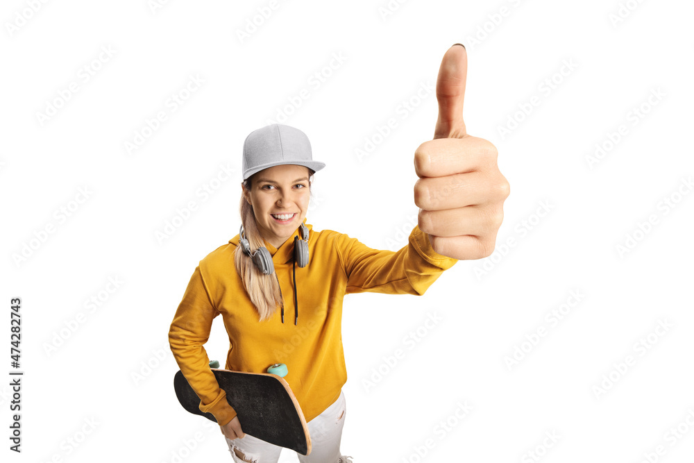 Female teenager with headphones and a skateboard showing a thumb up sign in front of camera Female teenager with headphones and a skateboard showing a thumb up sign in front of camera