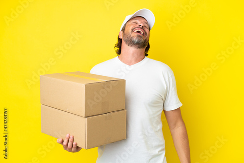 Delivery senior dutch man isolated on yellow background laughing