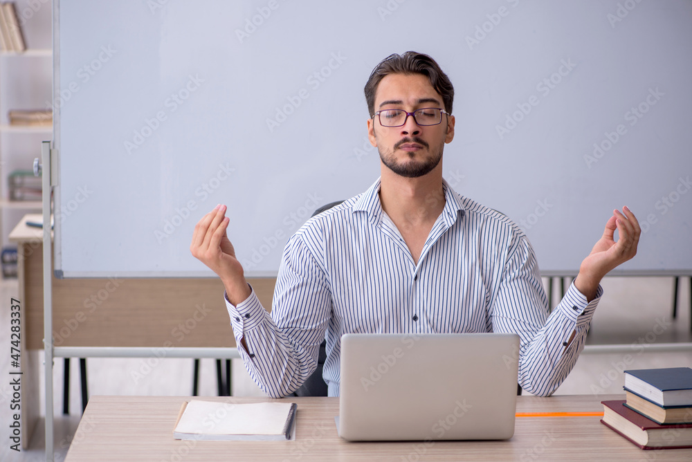 Young male teacher in the classroom Young male teacher in the classroom