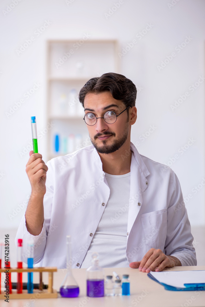 Young male chemist working at the lab