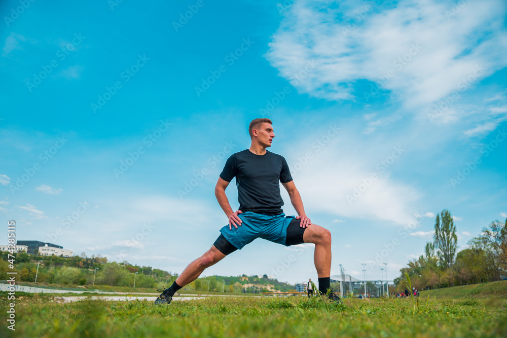 Man stretching hamstring arms muscles during outdoor crossfit workout Man stretching hamstring arms muscles during outdoor crossfit workout