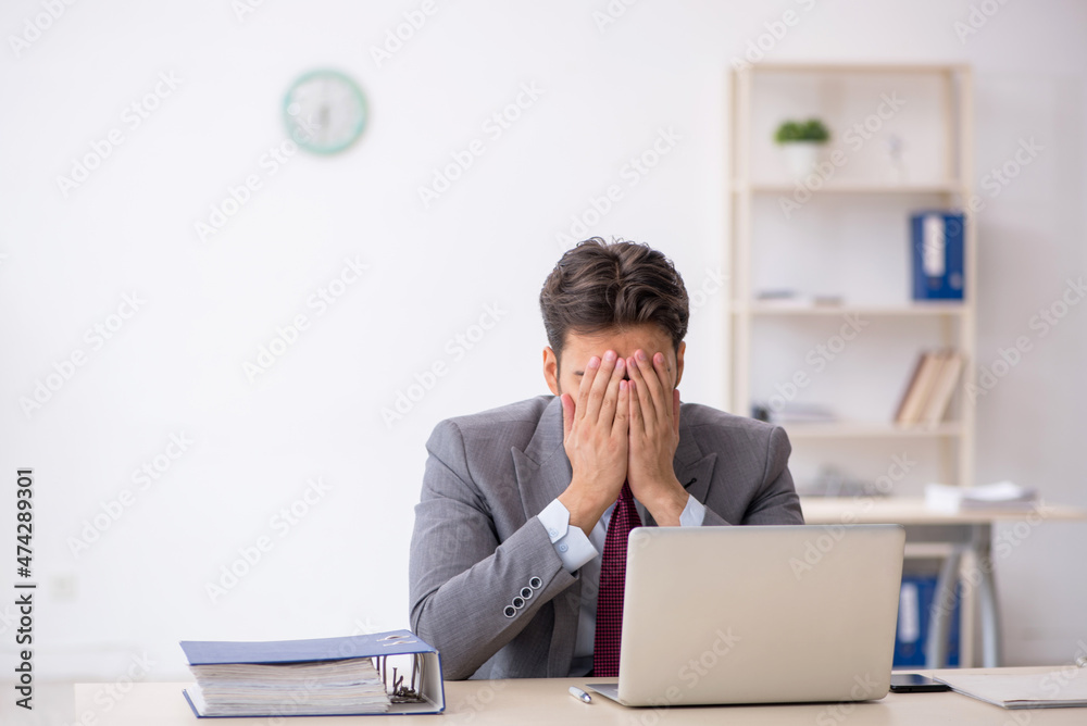 Young male employee working in the office Young male employee working in the office