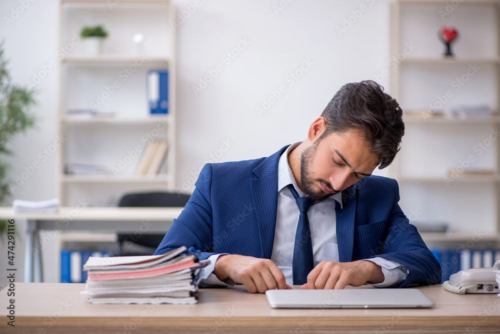 Fototapeta premium Young male employee extremely tired in the office
