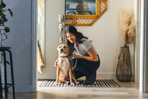 Happy Woman With Dog At Entrance Of Home