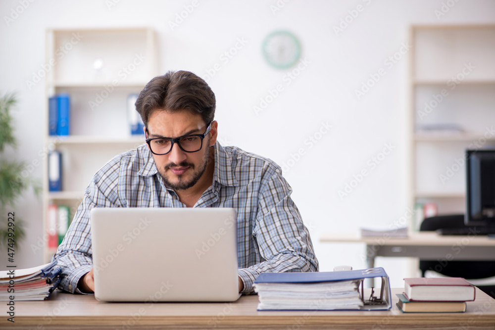 Young male employee sitting in the office Young male employee sitting in the office