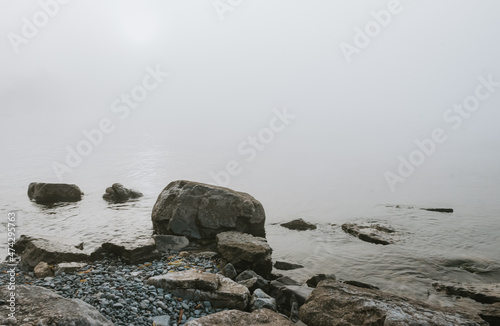 Rocky beach of Lake Ontario on a gray foggy day. photo