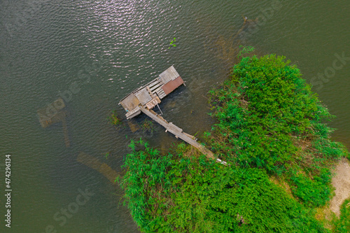 Fototapeta Aerial view of natural pond surrounded by pine trees