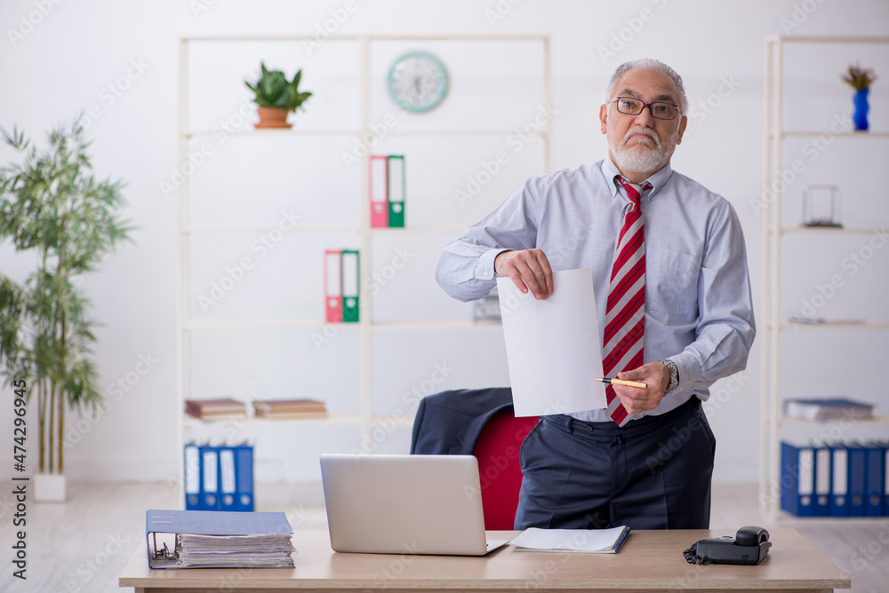 Old male employee working in the office Old male employee working in the office