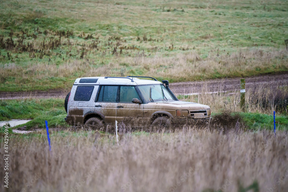 Land Rover Discovery 4x4 off-road vehicle driving across mud, water-logged terrain and wading through deep water pools, Wilts UK. Land Rover Discovery 4x4 off-road vehicle driving across mud, water-logged terrain and wading through deep water pools, Wilts UK.