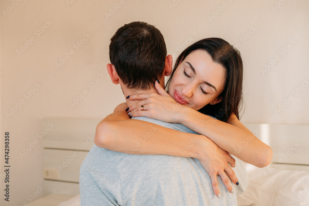 Happy woman hugs her husband, glad to meet or present. Loving young girlfriend with her beloved boyfriend, hugs, holding in an embrace. Family relations concept. Happy woman hugs her husband, glad to meet or present. Loving young girlfriend with her beloved boyfriend, hugs, holding in an embrace. Family relations concept.