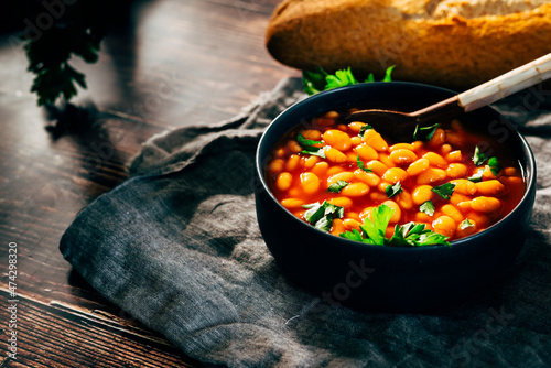 Black bowl full of beans with tomato sauce photo