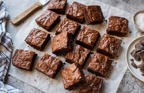 Top view of chocolate brownies cut into squares on paper. photo