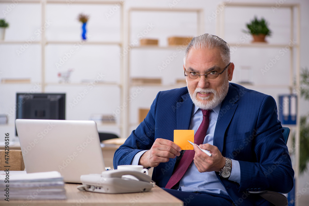 Old male employee working in the office Old male employee working in the office