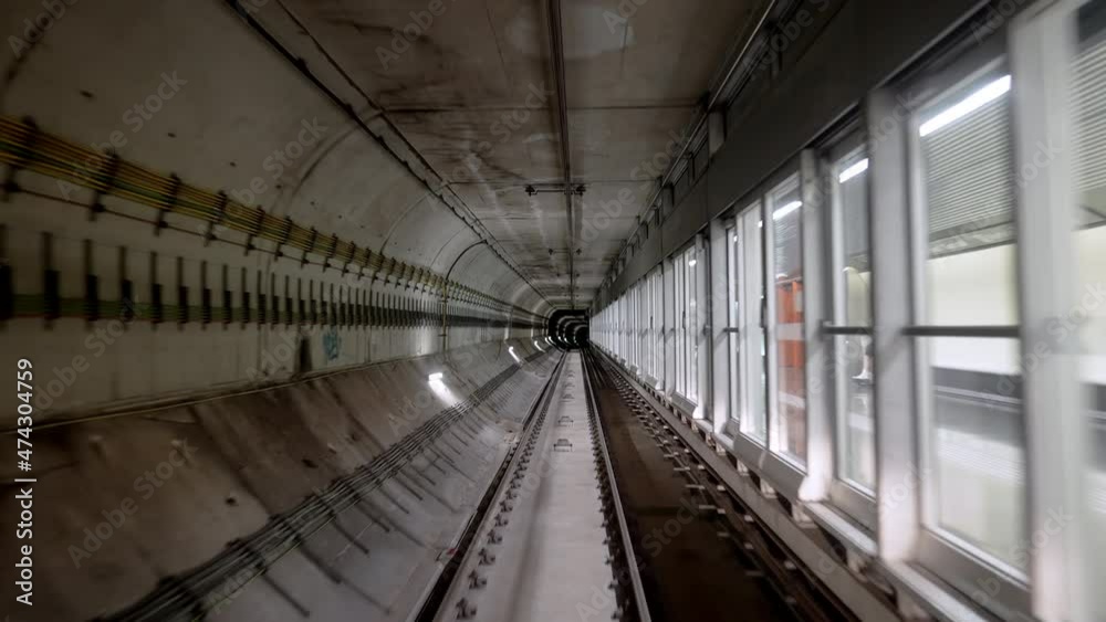 Front cabin view of moving subway carriage between airport terminals. Riding driverless metro train in Barcelona. Advanced transportation system, underground tunnel. Front cabin view of moving subway carriage between airport terminals. Riding driverless metro train in Barcelona. Advanced transportation system, underground tunnel.