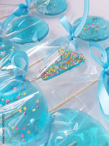 A blue lollipop in the shape of a number one in a festive package