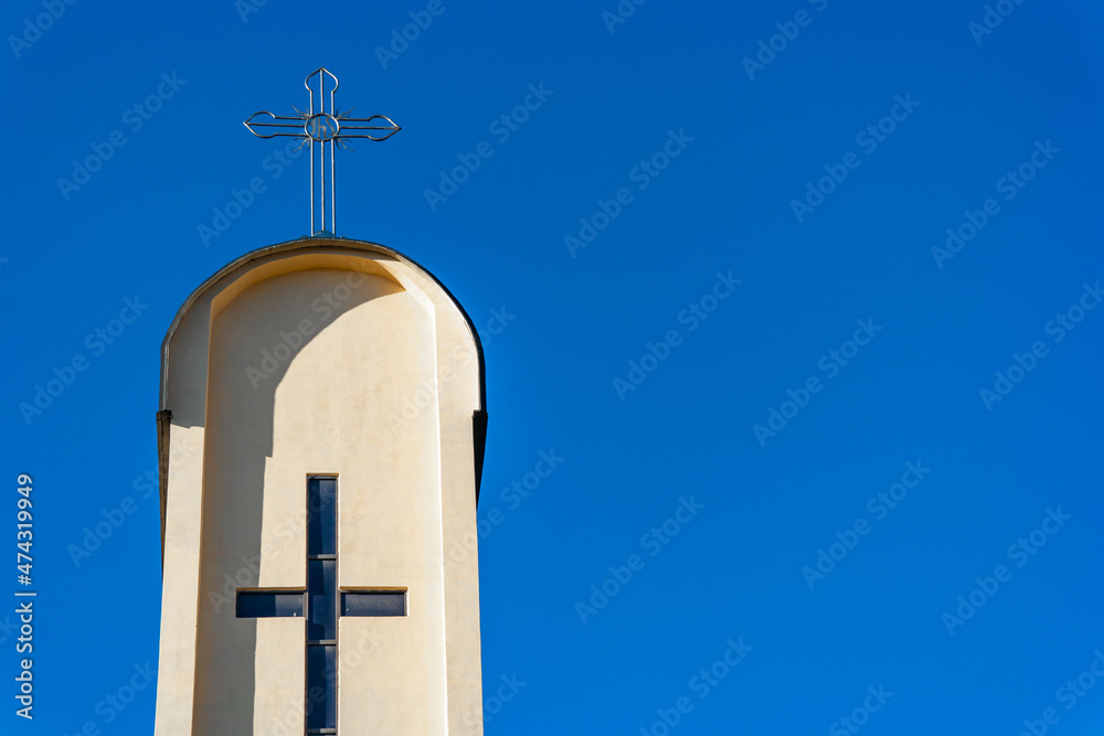 Cross on top of catholic tower church against deep blue sky Cross on top of catholic tower church against deep blue sky