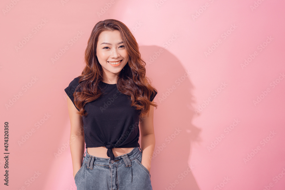 Portrait of charming curly-haired woman in trendy garment smiling broadly and glancing at camera over pastel background. Portrait of charming curly-haired woman in trendy garment smiling broadly and glancing at camera over pastel background.