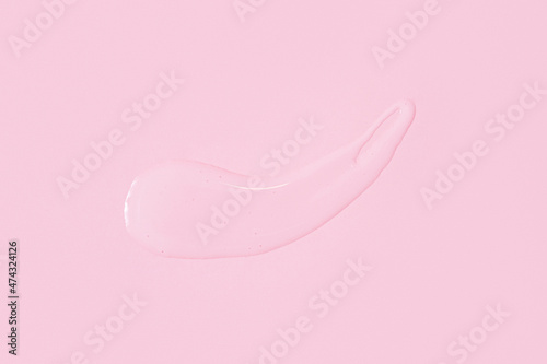 On pink background smeared transparent serum
