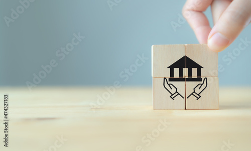 Good governance policy concept. Business moral principles concept. Businessman holds the wooden cubes with symbols hand holding the governance on beautiful grey background and copy space.