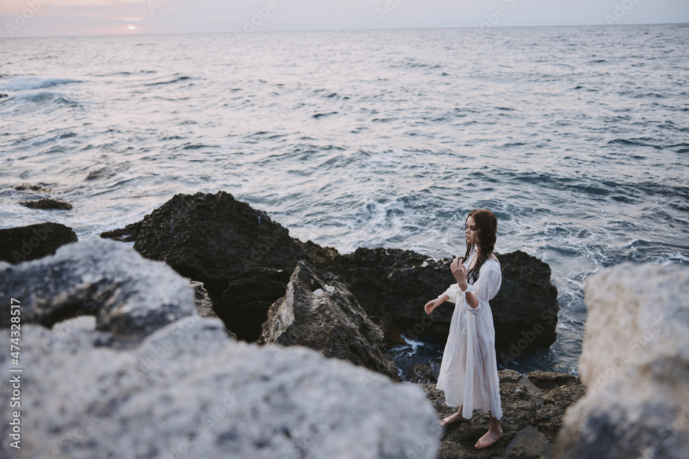 Woman in white coat stones nature weather ocean freedom