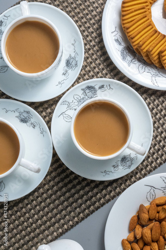 Tea time with Biscuits and dry fruits, White Plan Cashew, and Almonds.
seave in the white marble Tea set.  photo