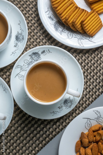 Tea time with Biscuits and dry fruits, White Plan Cashew, and Almonds.
seave in the white marble Tea set.  photo