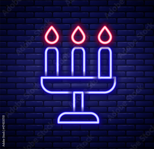 Glowing neon line Candelabrum with three candlesticks icon isolated on brick wall background. Colorful outline concept. Vector