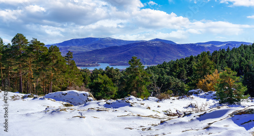 Panoramic mountain landscape with freshly fallen snow in the valley and lake in the background. Guadarrama, Madrid. photo