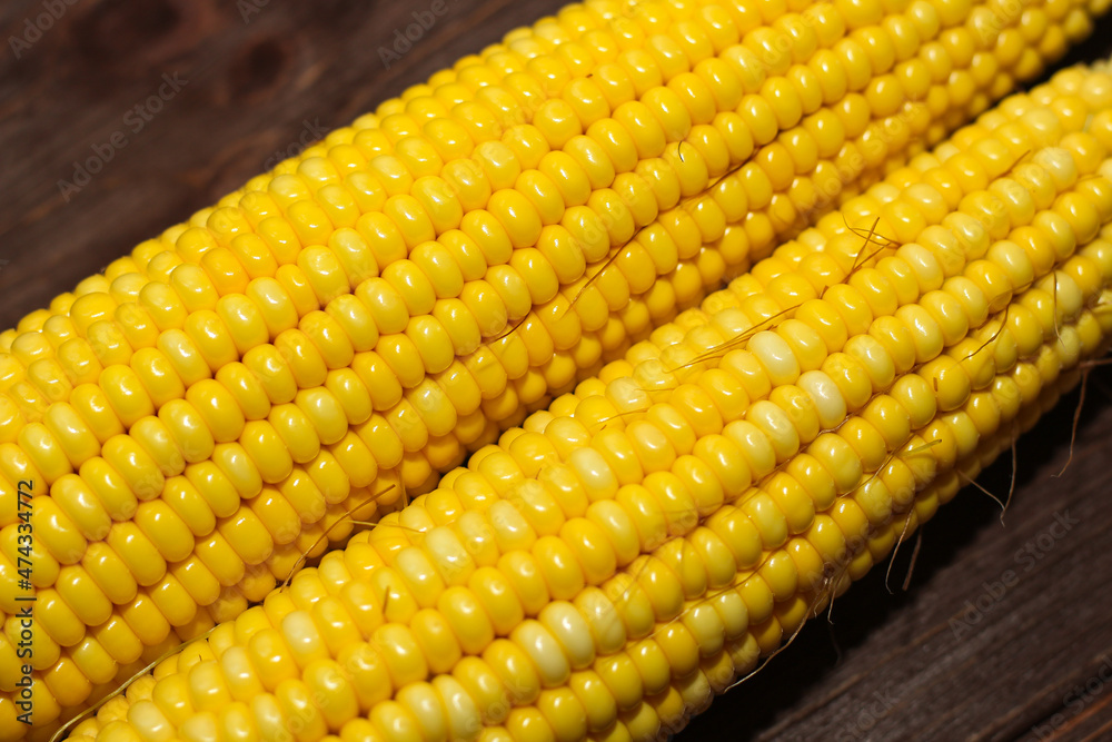 Sweet yellow corn lies on a wooden table. Sweet yellow corn lies on a wooden table.