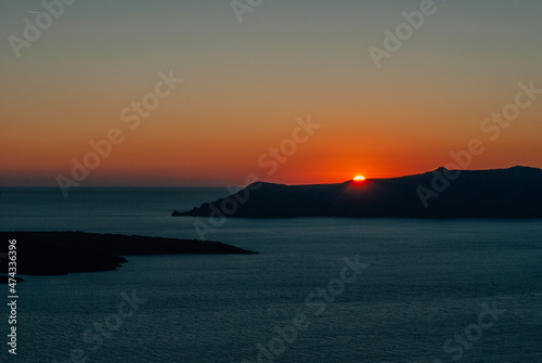 The sun at sunset almost disappeared behind the island, Santorini, Greece